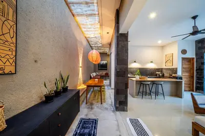 an open kitchen and living room with a table and chairs at Villa Tanaka Spacious Family Villa Berawa in Canggu