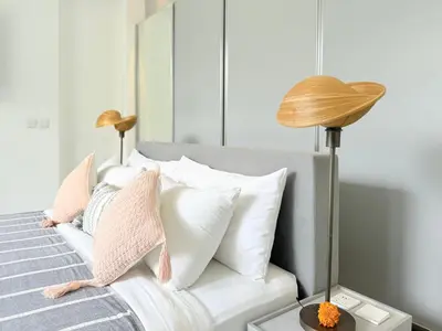 a bedroom with a white bed with pillows and a lamp at Umalas cozy 3 Bedrooms private pool villa in Kerobokan