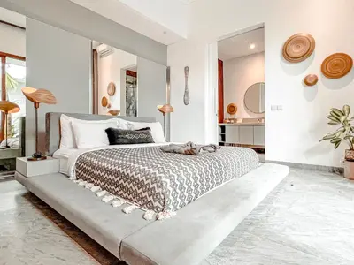 a bedroom with a large bed in a room with white walls at Umalas cozy 3 Bedrooms private pool villa in Kerobokan