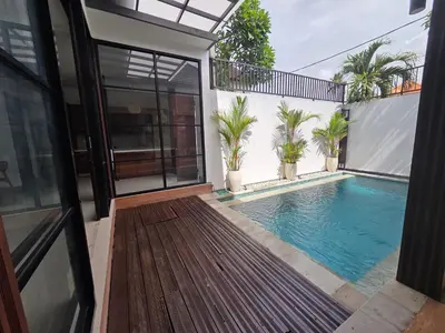 a house with a swimming pool and a balcony at Vila Hokyusa in Kerobokan