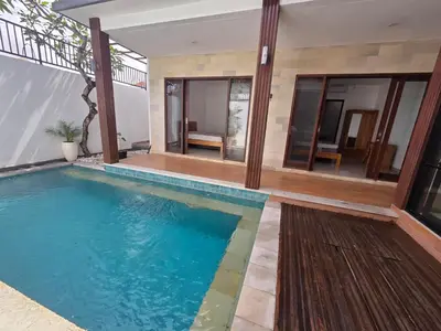 a swimming pool in the middle of a house at Vila Hokyusa in Kerobokan