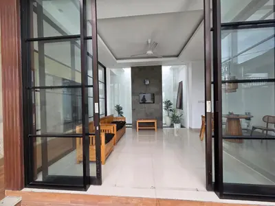 an open living room with sliding glass doors at Vila Hokyusa in Kerobokan