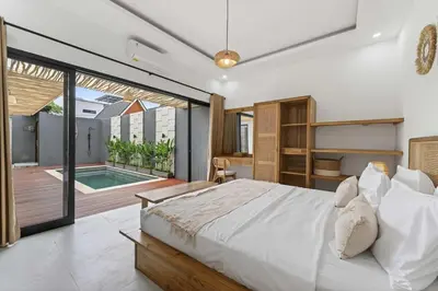 a bedroom with a large white bed and a balcony at Nara V11 2BR Escape in the Heart of Seminyak in Seminyak