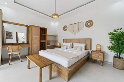 a bedroom with a large bed and a desk at Nara V11 2BR Escape in the Heart of Seminyak in Seminyak