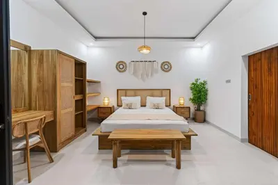 a bedroom with a bed and a table and a desk at Nara V11 2BR Escape in the Heart of Seminyak in Seminyak