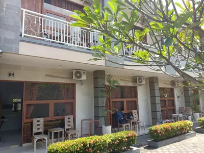 a building with chairs and tables and a balcony at Pondok Hokyusa in Seminyak