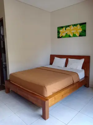 a bed in a room with a wooden frame at Pondok Hokyusa in Seminyak