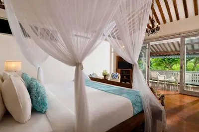 a bedroom with a white bed with a canopy at Dulcinea Spacious 5 BR Private Pool Villa in Jimbaran