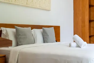 a large white bed with white sheets and pillows at Villa Semilir Pagi, Canggu in Canggu