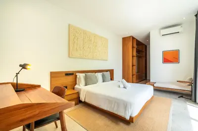 a bedroom with a large white bed and a desk at Villa Semilir Pagi, Canggu in Canggu