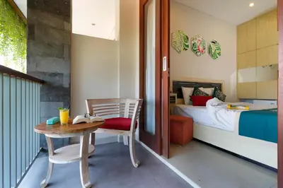 a room with a table and a bed and a bedroom at Vansari Hotel in Seminyak
