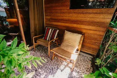two chairs sitting on the porch of a house at Wow Cozy Lagoon! in Nusa Dua