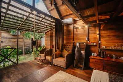 a living room with a couch and chairs in a room with wooden walls at Wow Cozy Lagoon! in Nusa Dua