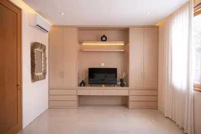 a living room with a flat screen tv at Luxury 3BR Canggu | Billiards | Outdoor Cinema in Canggu