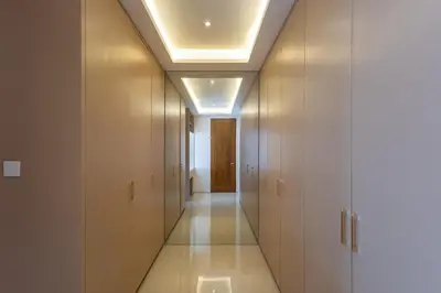 a hallway with white cabinets and a ceiling at Luxury 3BR Canggu | Billiards | Outdoor Cinema in Canggu