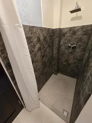 a bathroom with a shower with a glass door at Happy's house Bali in Kerobokan