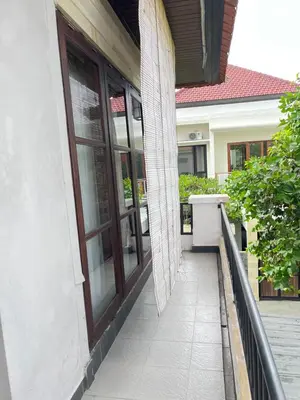 a balcony with glass doors on a house at Kubu In Dhana Sanur Guest House in Mantaak