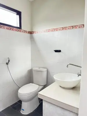 a bathroom with a toilet and a sink at Kubu In Dhana Sanur Guest House in Mantaak