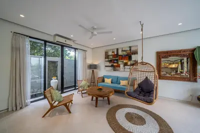 a living room with a blue couch and a swing at Tropical 3BR Oasis w Private Pool Villa Nau Mai in Seminyak