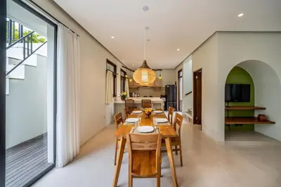 a dining room with a wooden table and chairs at Tropical 3BR Oasis w Private Pool Villa Nau Mai in Seminyak