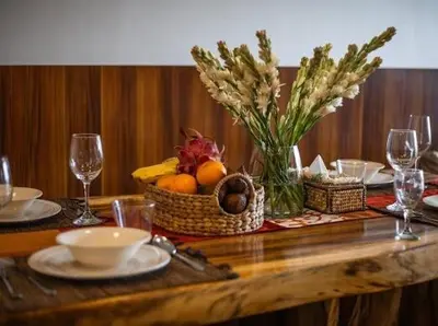 a wooden table with a basket of fruit and wine glasses at villa dreamland beach 300 meter private walk in Jimbaran