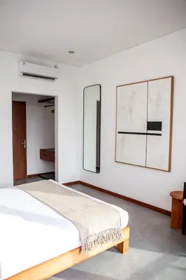 a white bedroom with a bed and two mirrors at Villa Kenia 1 in Umalas, near Canggu in Canggu