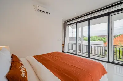 a bedroom with a bed and a large window at Villa Orchid Heaven by Bali Villa Solutions in Seminyak