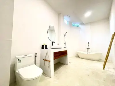 a bathroom with a toilet and a sink and a tub at Dakings Greece House in Legian