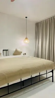 a bedroom with a large bed and a pendant light at Dakings Greece House in Legian