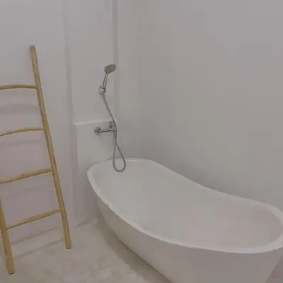 a white bath tub in a room with a ladder at Dakings Greece House in Legian