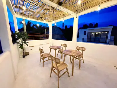 a patio with four chairs and a table on a porch at Dakings Greece House in Legian