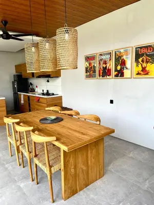 a dining room with a wooden table and chairs at Rumah Melissa - Modern Boho 3BR Brand New Villa in Sanur in Sanur