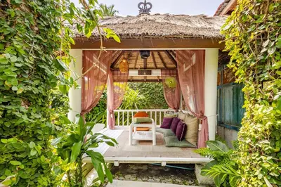 a porch of a house with pink curtains at Charming, Homely, Pool, Lush Gardens, Umalas, Cozy in Kerobokan