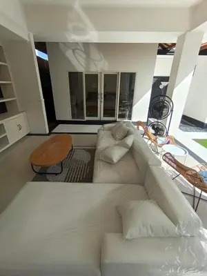 a living room with a white couch and a table at Villa Bu H in Kerobokan