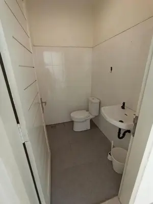 a small bathroom with a toilet and a sink at Villa Bu H in Kerobokan