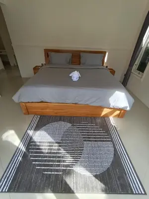 a bedroom with a bed with a bedspread on it at Villa Bu H in Kerobokan