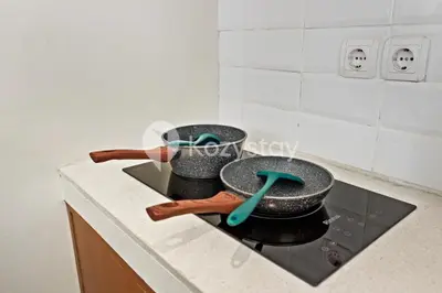 a stove with two pans on top of it at Kirelo Villa by Kozystay - Sanur in Sanur