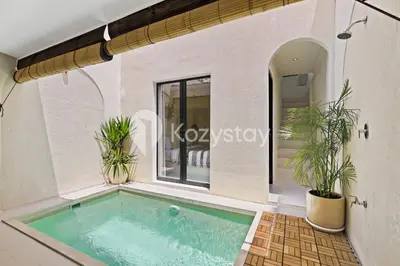 a swimming pool in a house with two potted plants at Kirelo Villa by Kozystay - Sanur in Sanur
