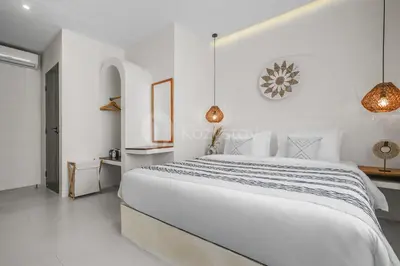 a white bedroom with a large bed in a room at Kirelo Villa by Kozystay - Sanur in Sanur