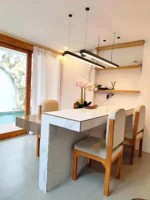 a dining room with a table and chairs with flowers on it at Coconut Villa in Kerobokan