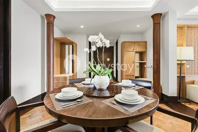 a dining room table with a vase of flowers on it at The Koral by Kozystay - Seminyak in Kuta