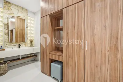 a bathroom with a wooden wall next to a sink at Sadin Villa by Kozystay - Umalas in Kerobokan