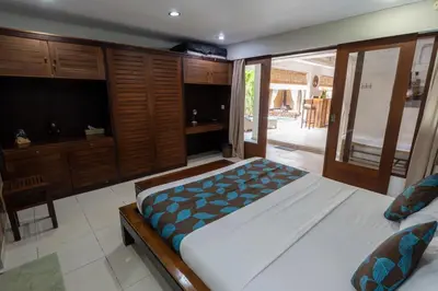 a bedroom with a large bed and wooden cabinets at Kangin villa 2 bedrooms in the heart of Seminyak in Kuta