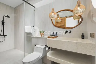 a bathroom with a toilet and a mirror and a sink at Salila Villa by Kozystay - Umalas in Kerobokan
