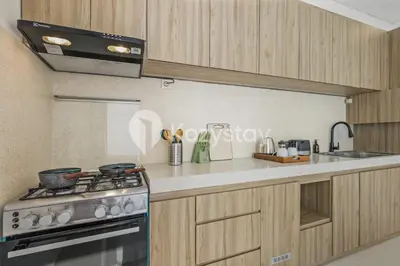 a kitchen with wooden cabinets and a stove top oven at Salila Villa by Kozystay - Umalas in Kerobokan