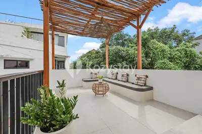 a patio with a wooden pergola and potted plants at Salila Villa by Kozystay - Umalas in Kerobokan