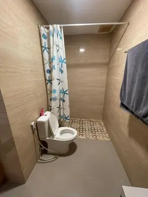 a bathroom with a toilet with a shower curtain at Ariani Villa in Jimbaran