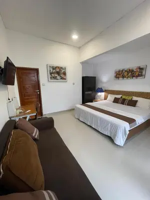 a bedroom with a large bed and a couch at Ariani Villa in Jimbaran