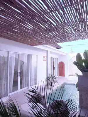 a house with a wooden ceiling and some plants at Villa Grand in Sanur