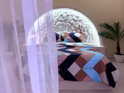 a bedroom with a bed with an arched window at Villa Grand in Sanur
